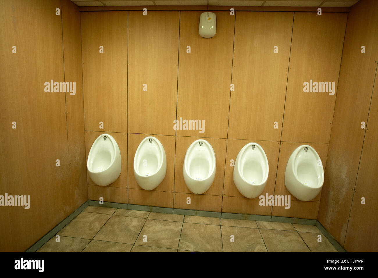 Five white urinals in a men`s toilet UK Stock Photo